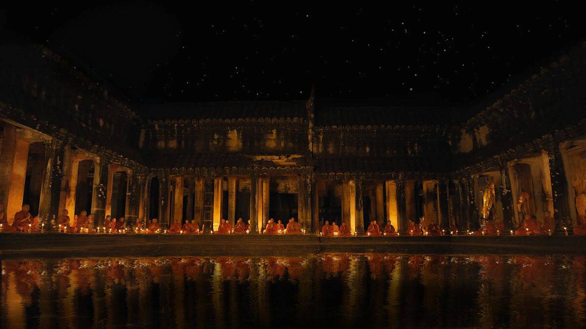 Monks meditating in a temple courtyard at night