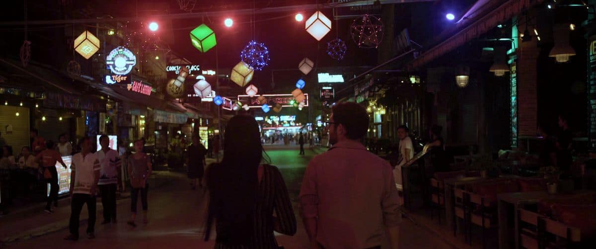 Lit street lined with restaurants at night